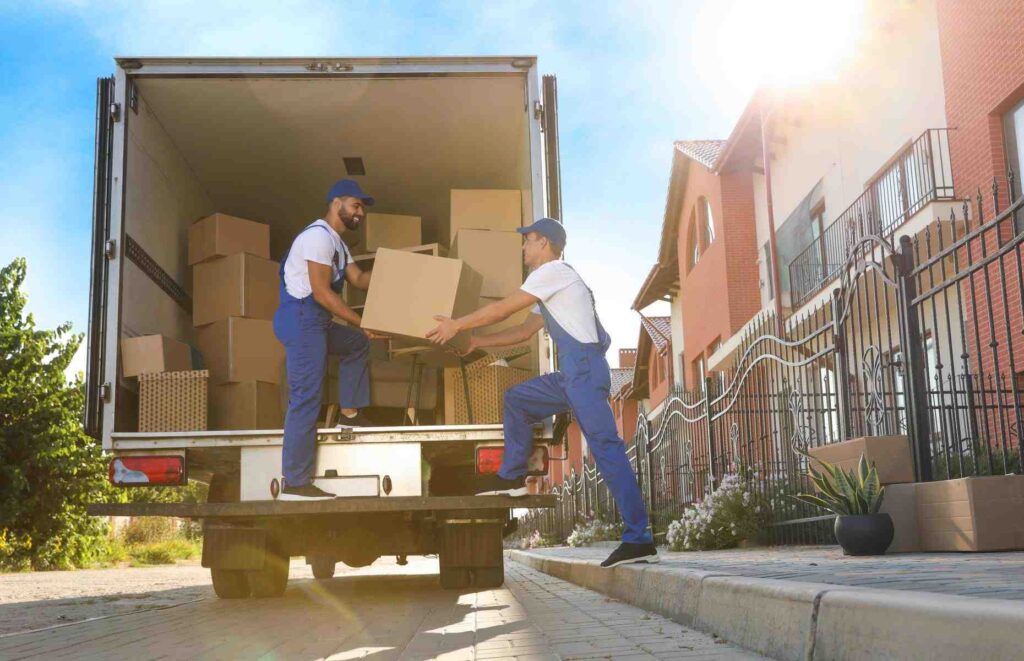 Best movers and packers in Dubai professionally loading boxes from a suburban home onto the moving truck, showcasing safe and efficient handling during a project.