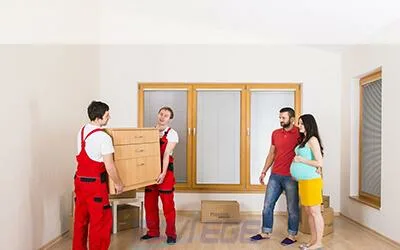Professional team of the best movers and packers in Dubai standing ready with a van full of securely packed boxes, providing reliable moving service.